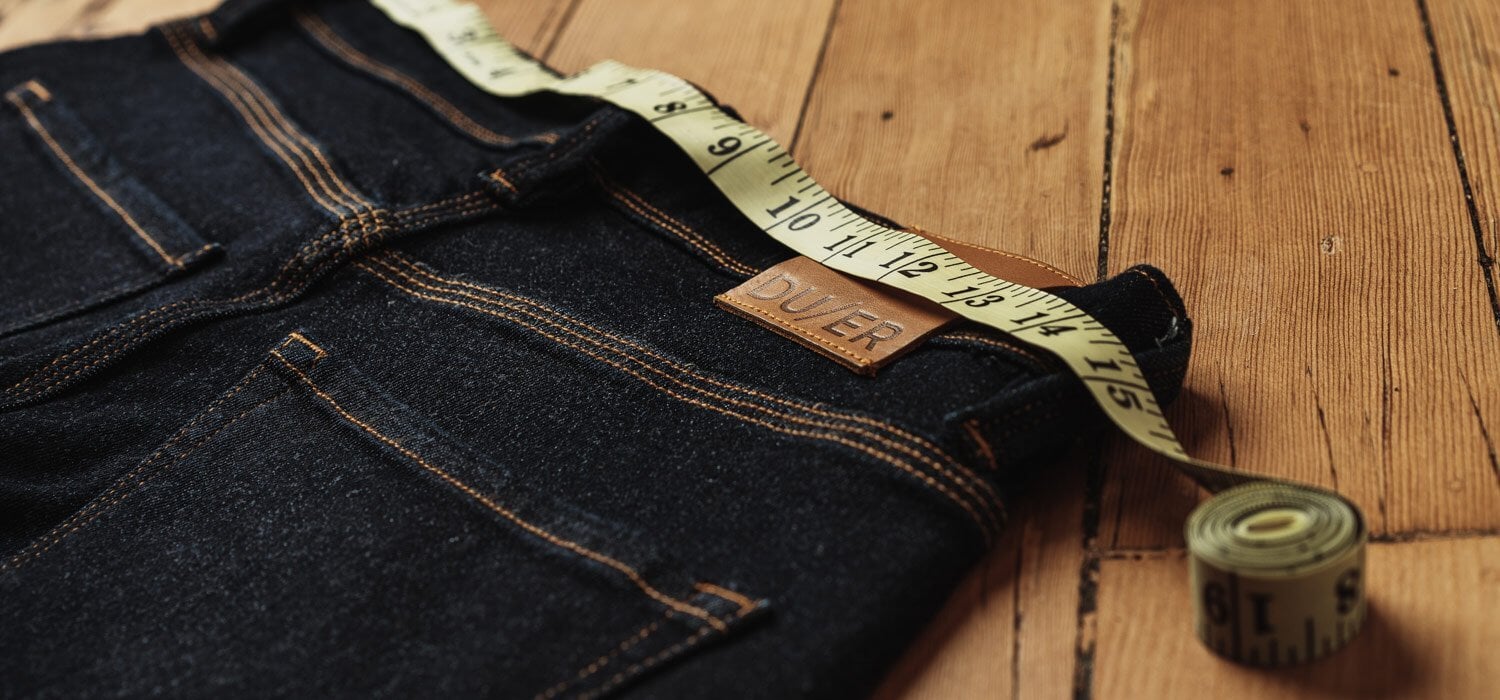 A pair of jeans being measured at the waist
