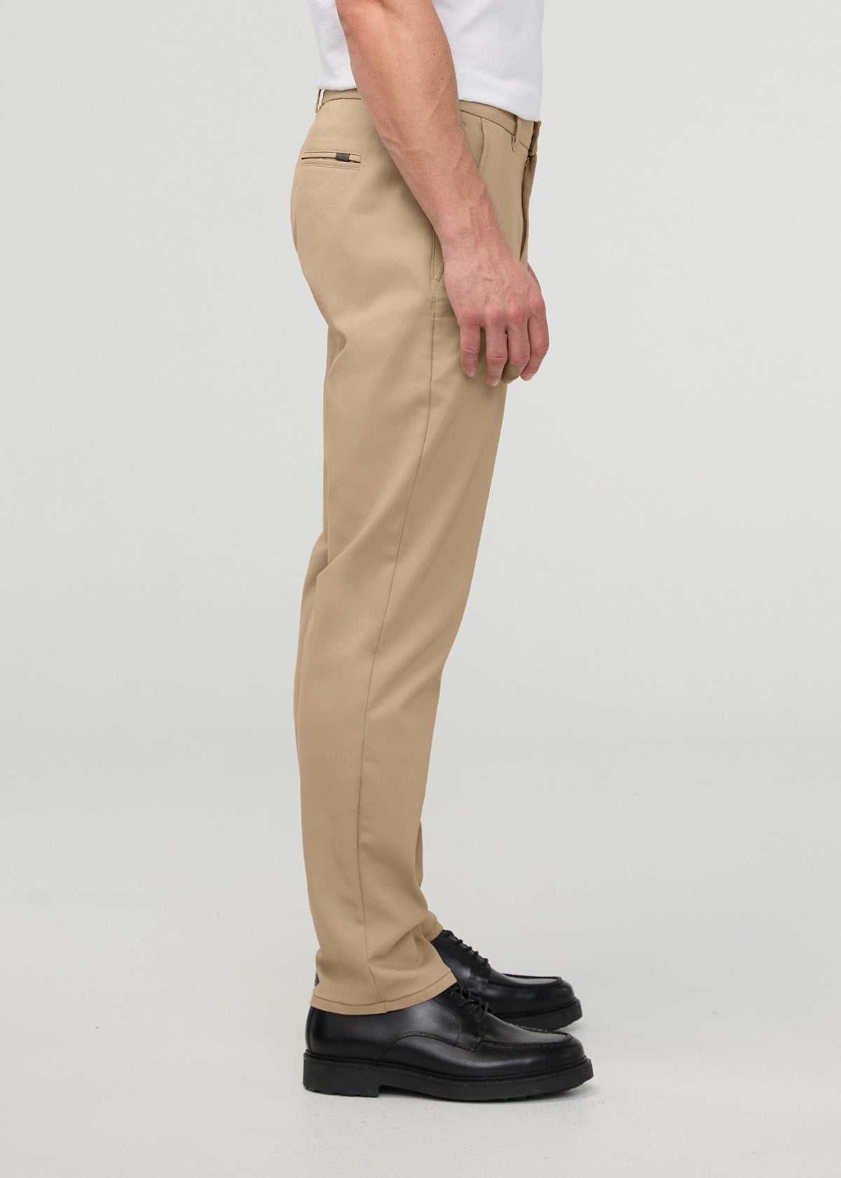 Men's khaki relaxed taper trouser with tapered ankle, shown in side profile with white shirt and black shoes.