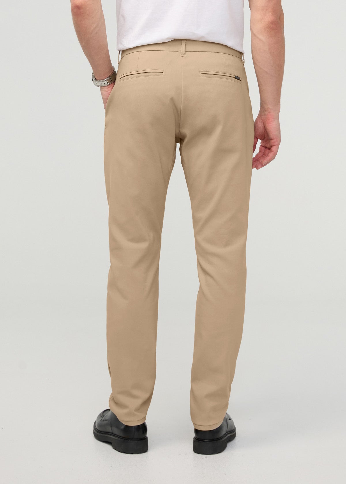 Khaki relaxed taper trouser with back flap pockets, shown from behind on a model wearing a white t-shirt.