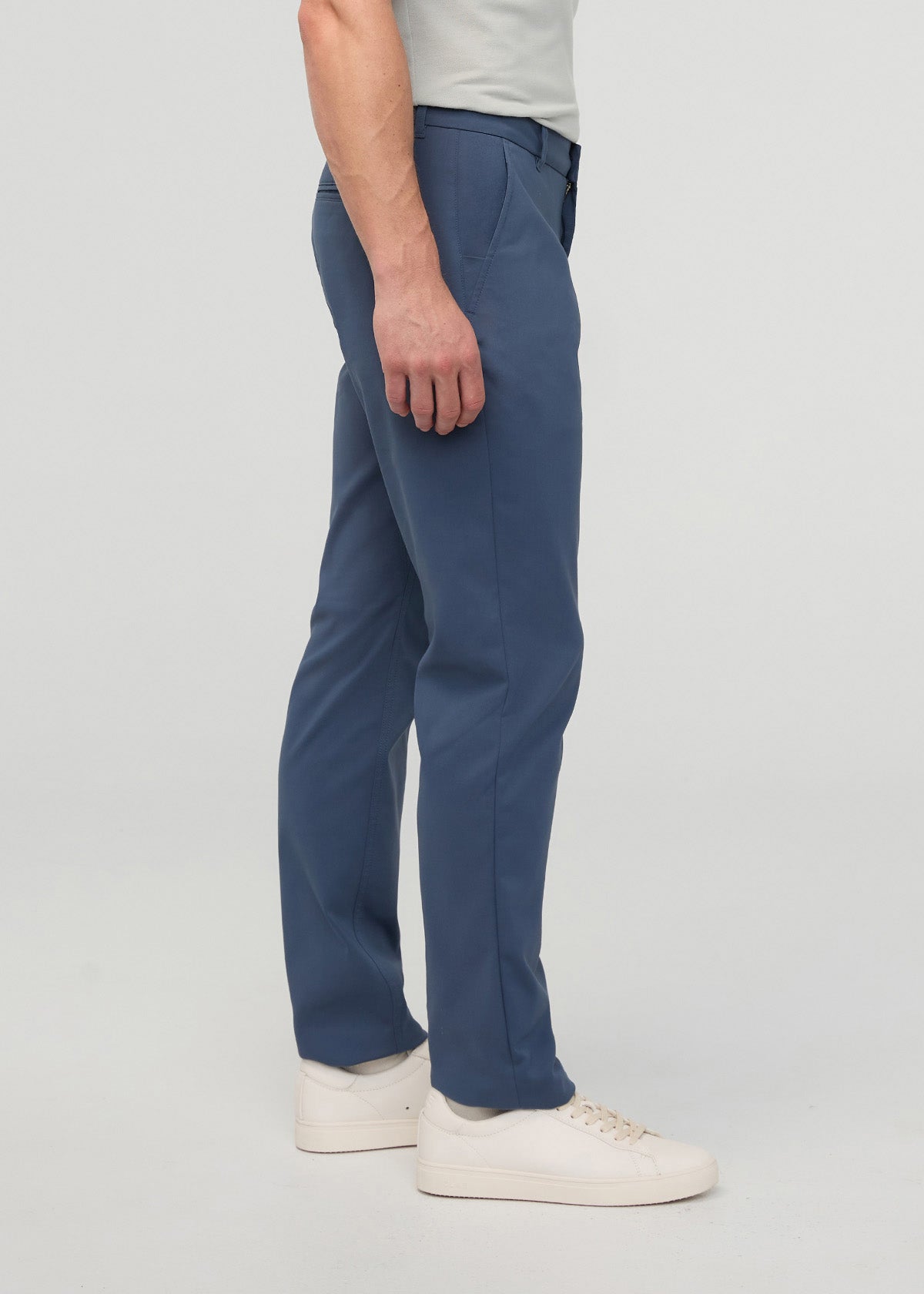 Man wearing heritage blue relaxed taper trousers with white sneakers and light gray t-shirt.