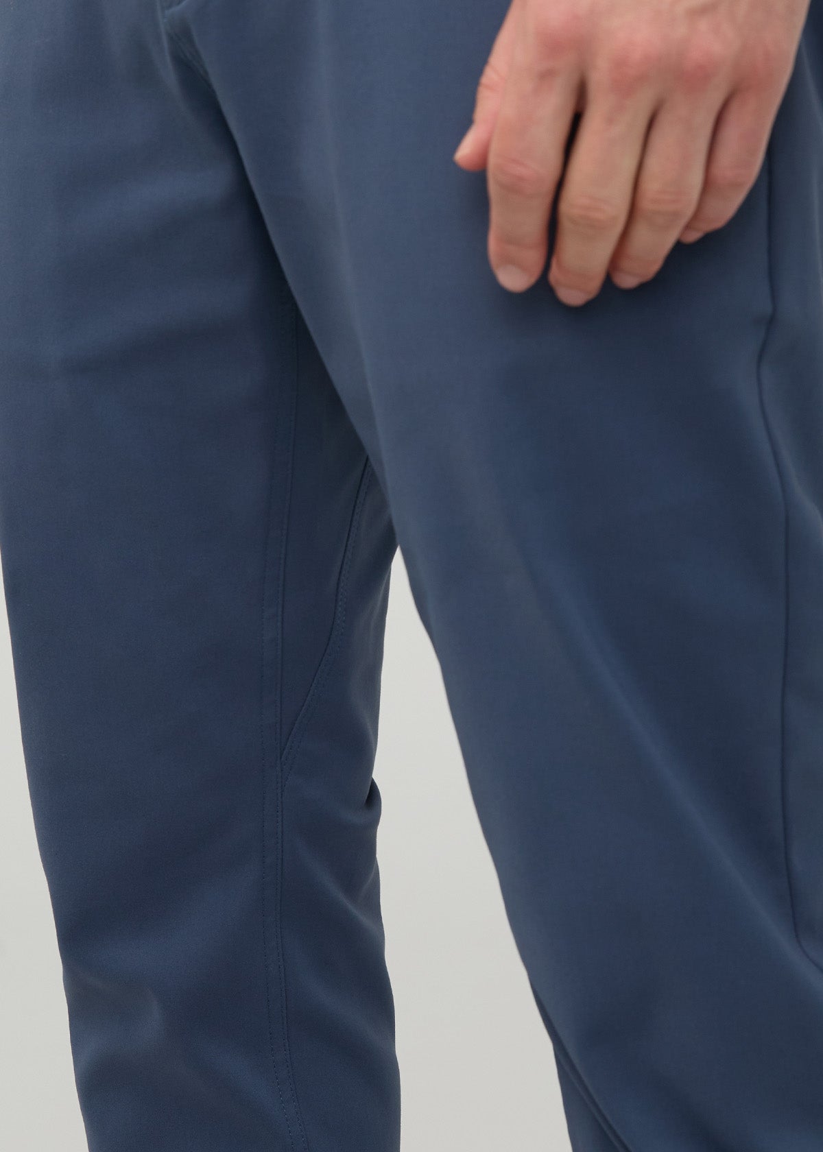 Heritage blue tapered trousers with relaxed fit through thigh, shown from waist to knee with hand in pocket.