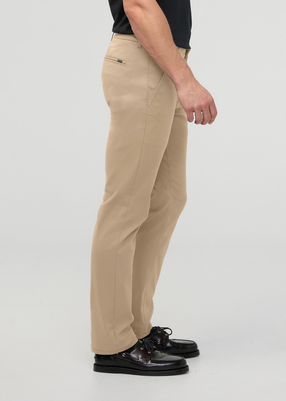 Beige slim straight trouser with back pocket detail, shown on model wearing black shirt and black shoes.