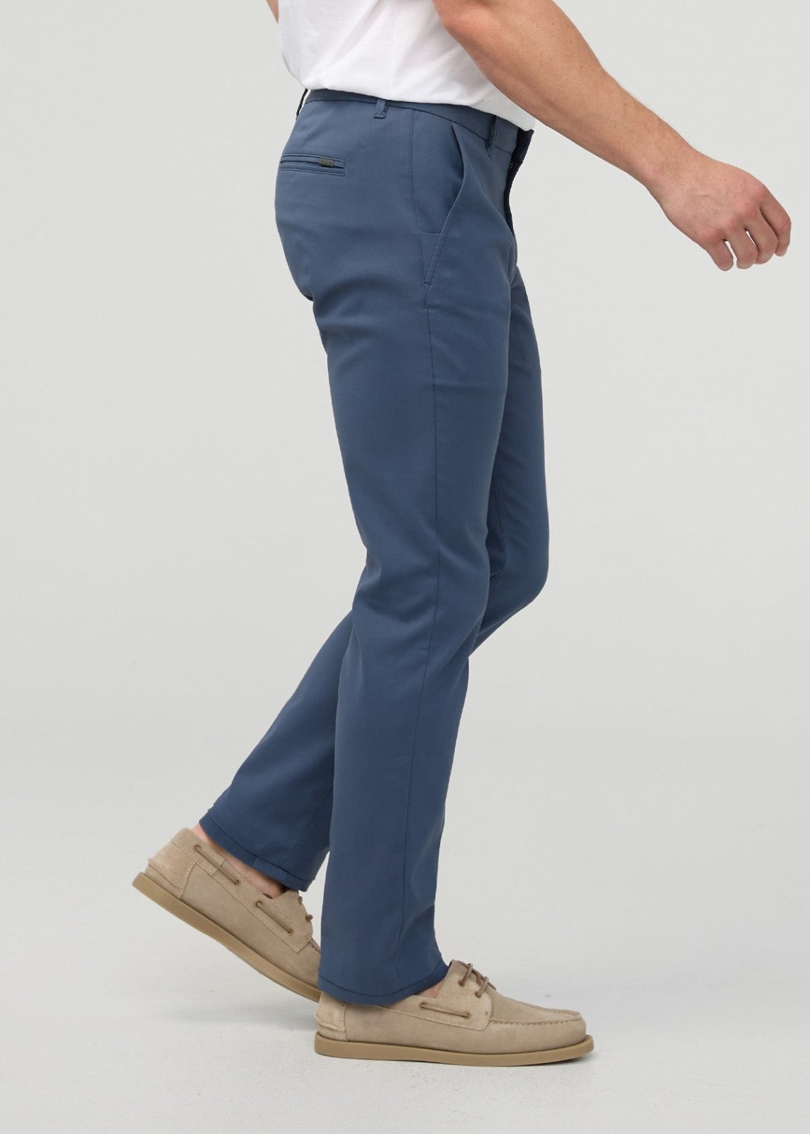 Heritage blue slim straight trousers with flat front and straight leg, shown on model wearing white shirt and tan shoes.