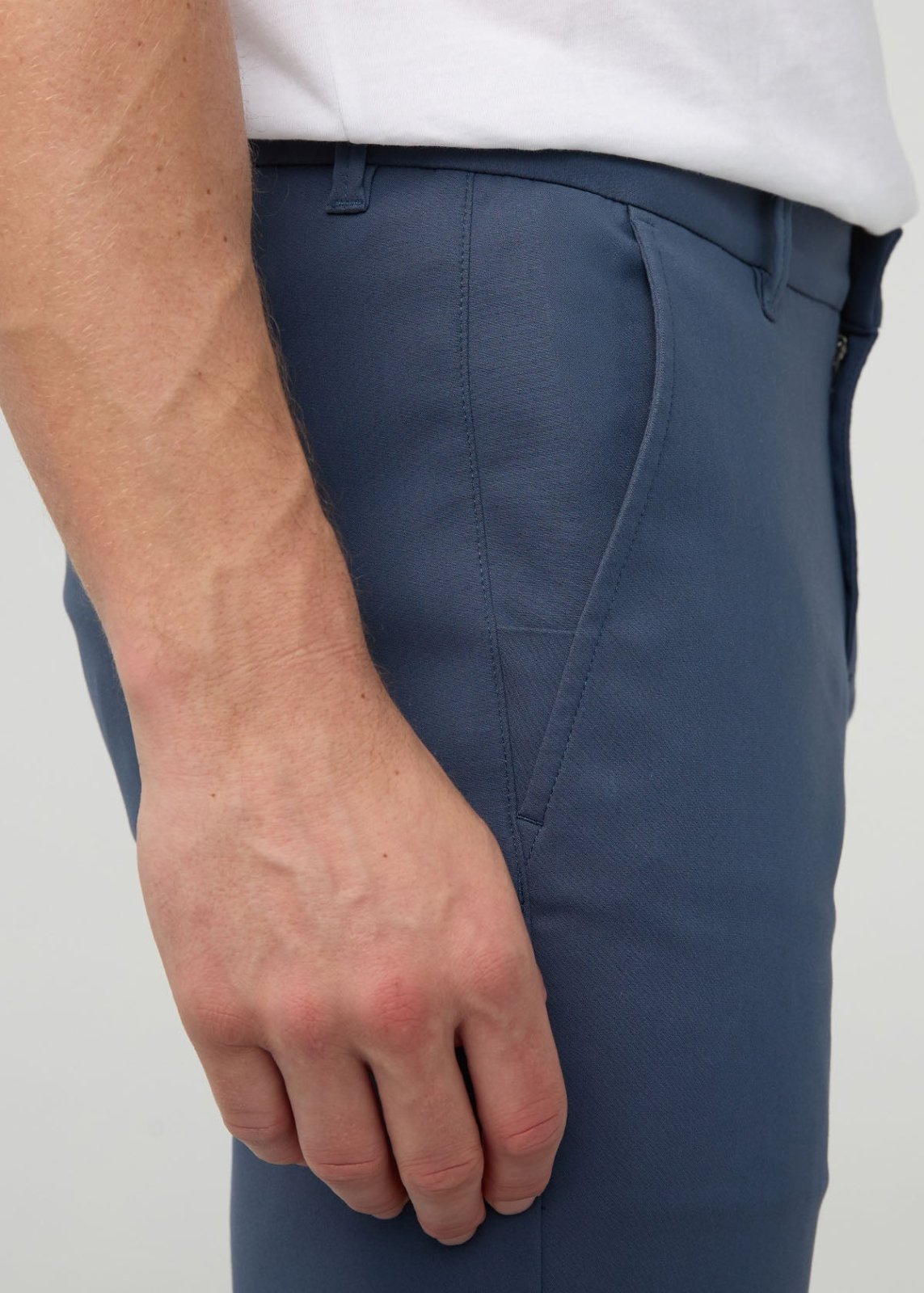 Dark blue slim straight trousers with flat front detail, worn with white shirt.