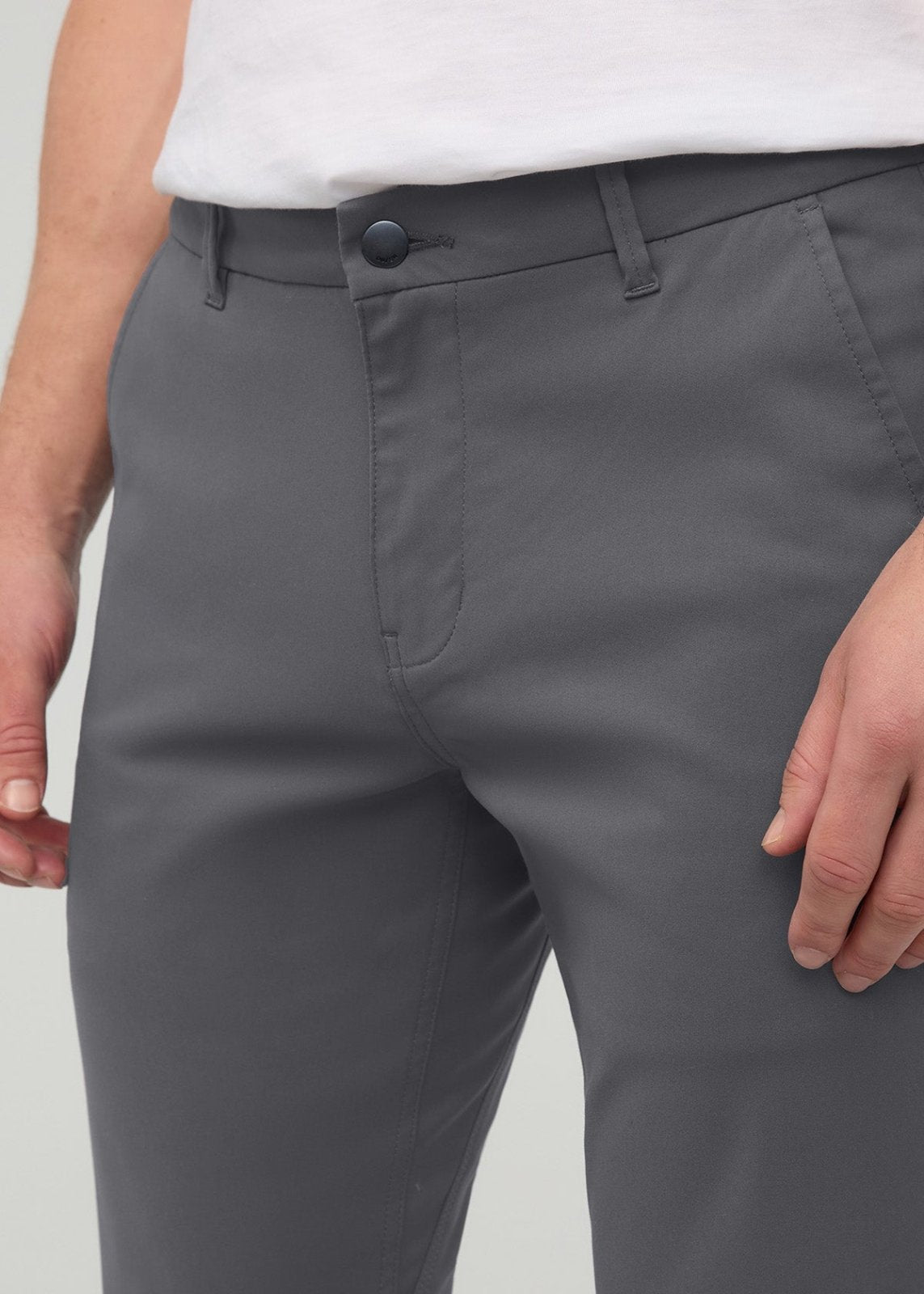 Gray slim straight trousers with button closure and flat front, worn with white top.