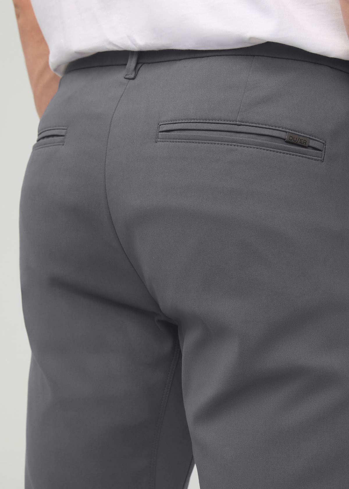 Gray slim straight trouser with back pocket detail, worn with white shirt.