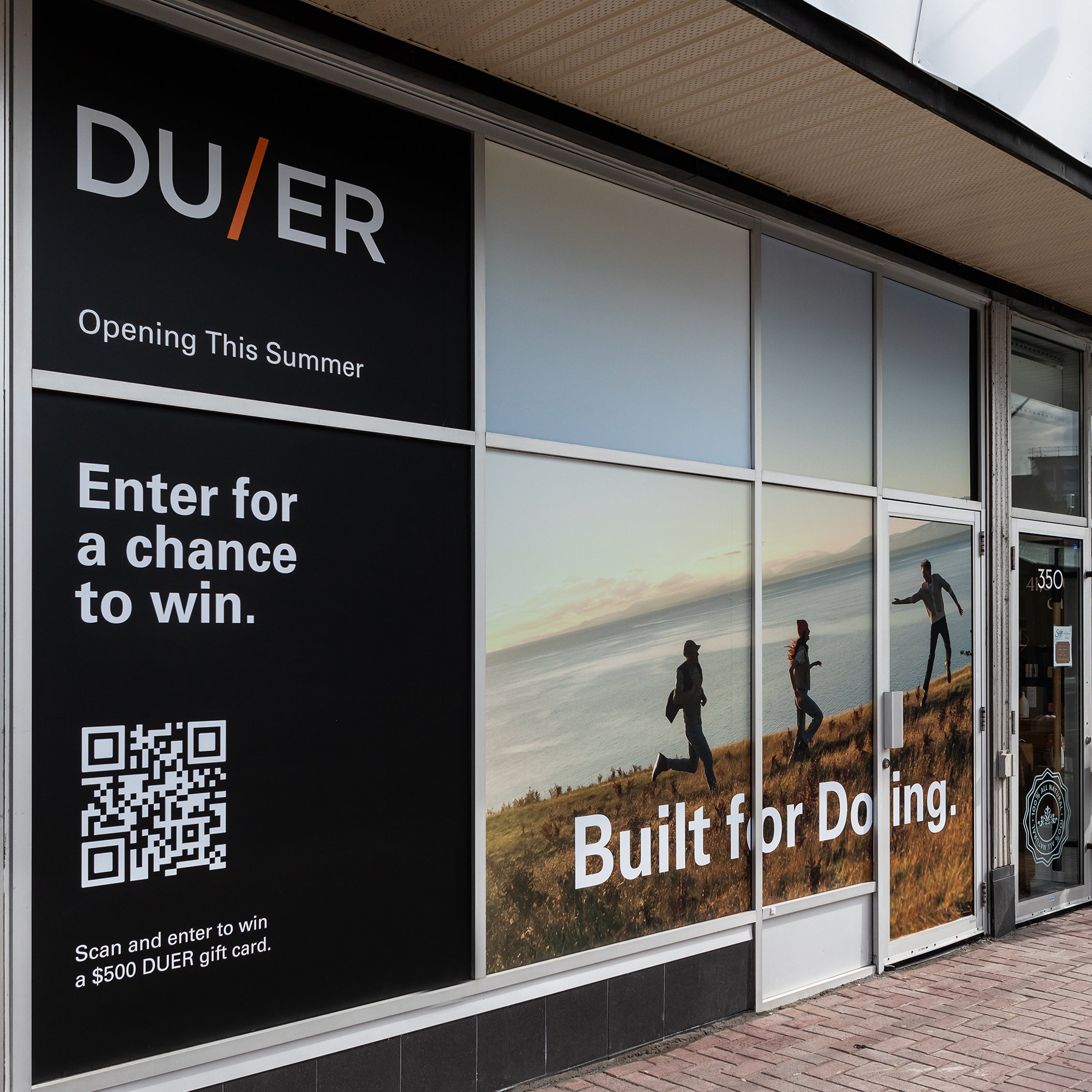 Storefront of DU/ER with promotional banners featuring people jogging by the seaside, a qr code for a contest