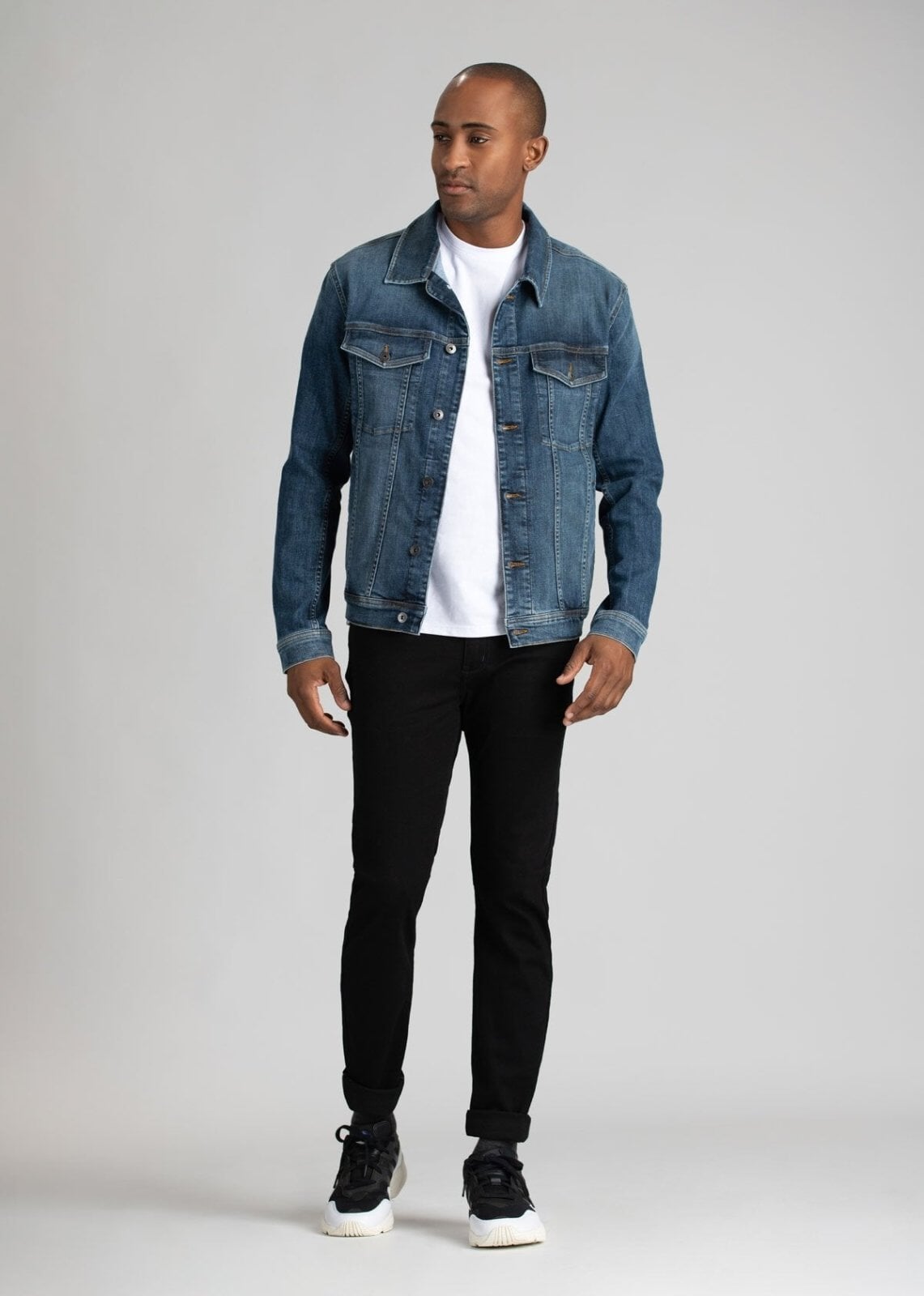 man wearing black water resistant slim jeans with a denim jacket